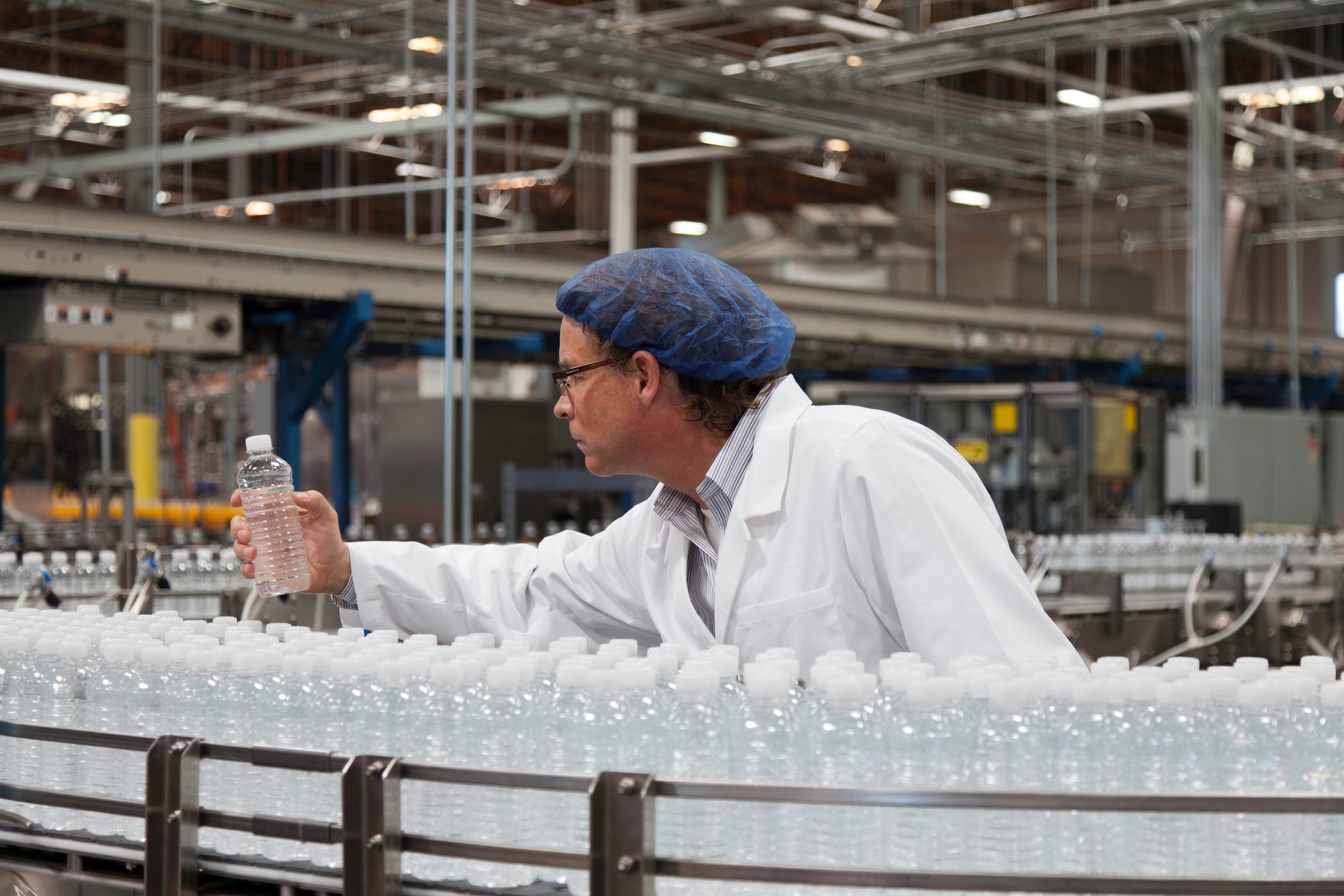 Factory worker examining bottled water