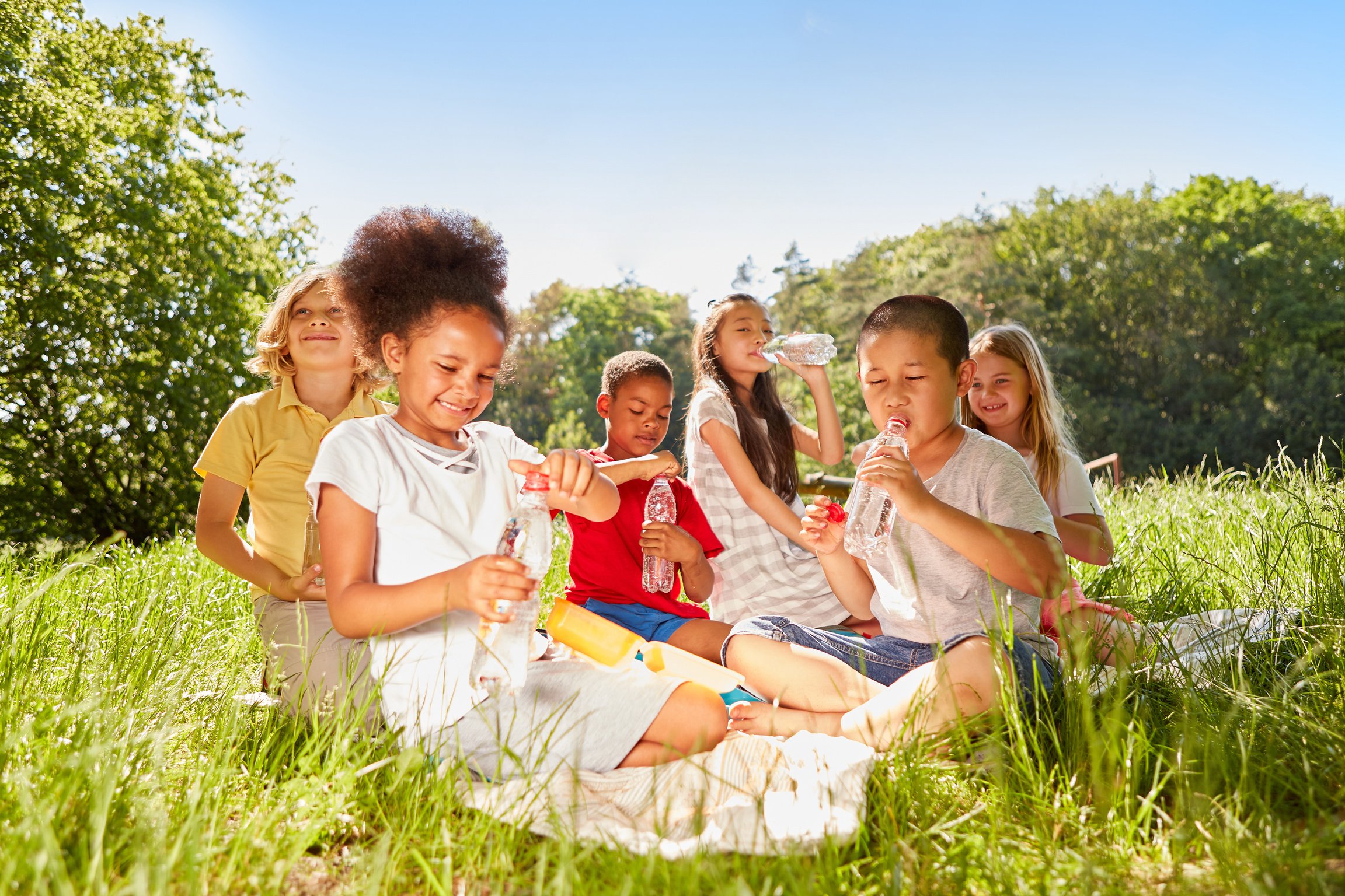 Kids in a Picnic Outdoors Drinking Water